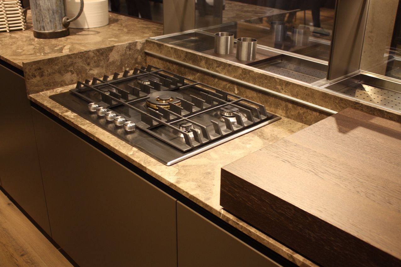 Even gas cooktops can be part of a hidden kitchen when a sliding cover is included. This is by Ernestomeda.