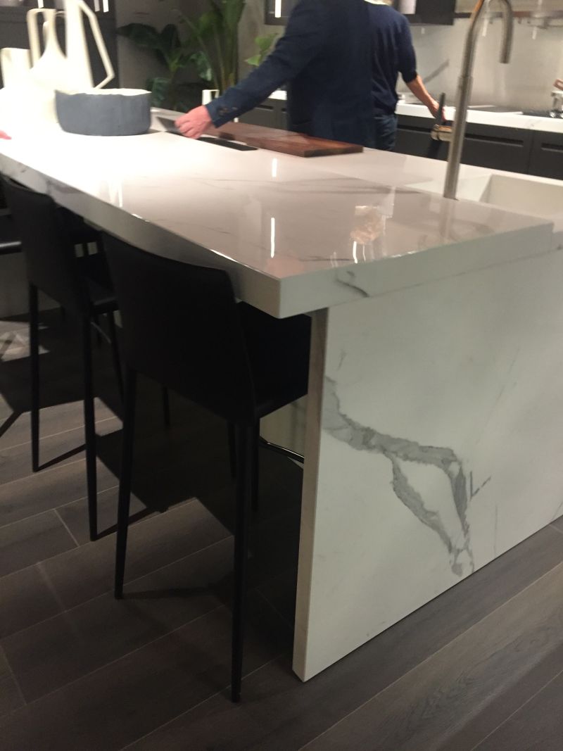 White marble kitchen island and stools under